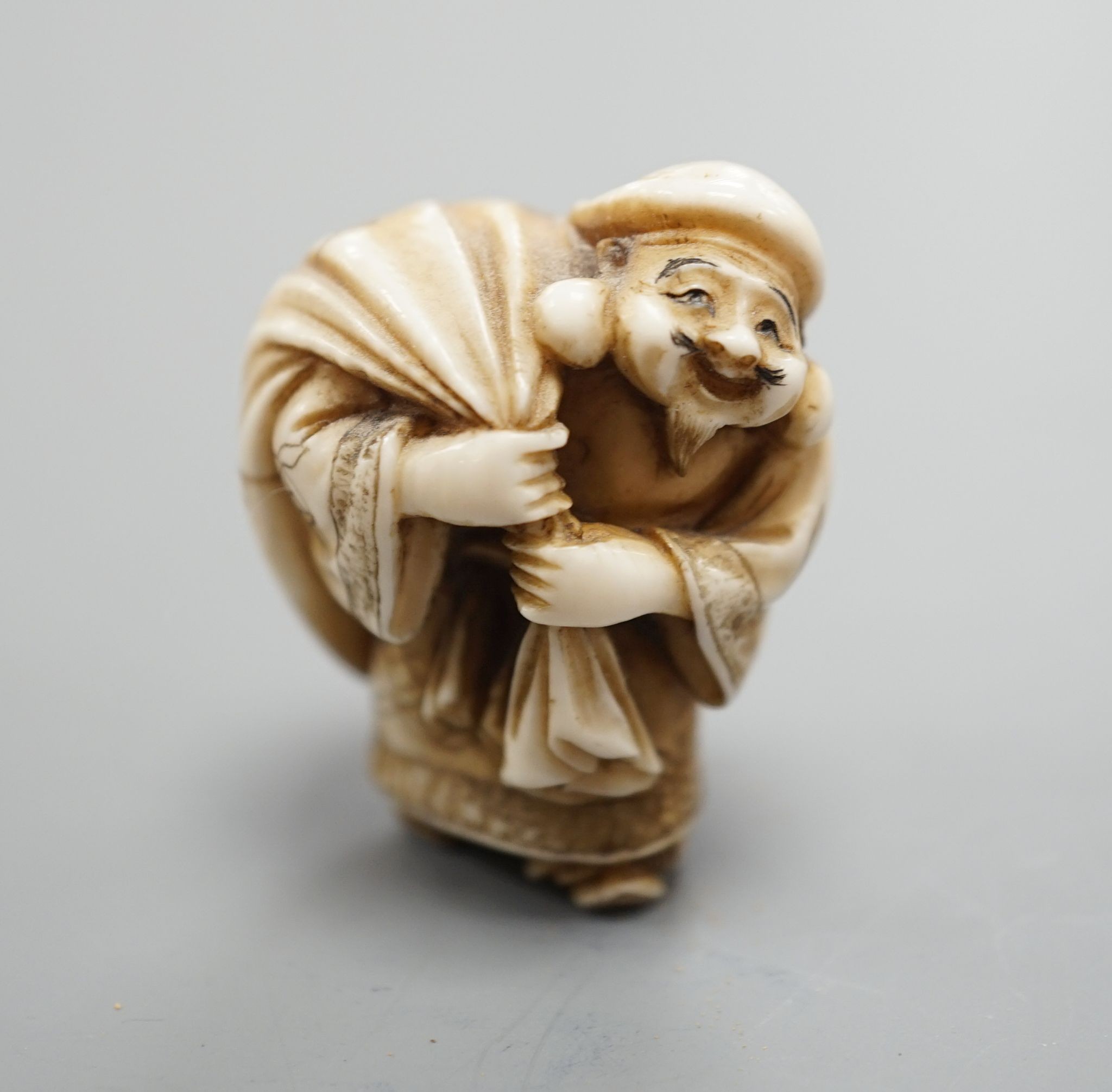 A Japanese ivory netsuke of Daikoku or Ebisu, Meiji period, 4 cms high.